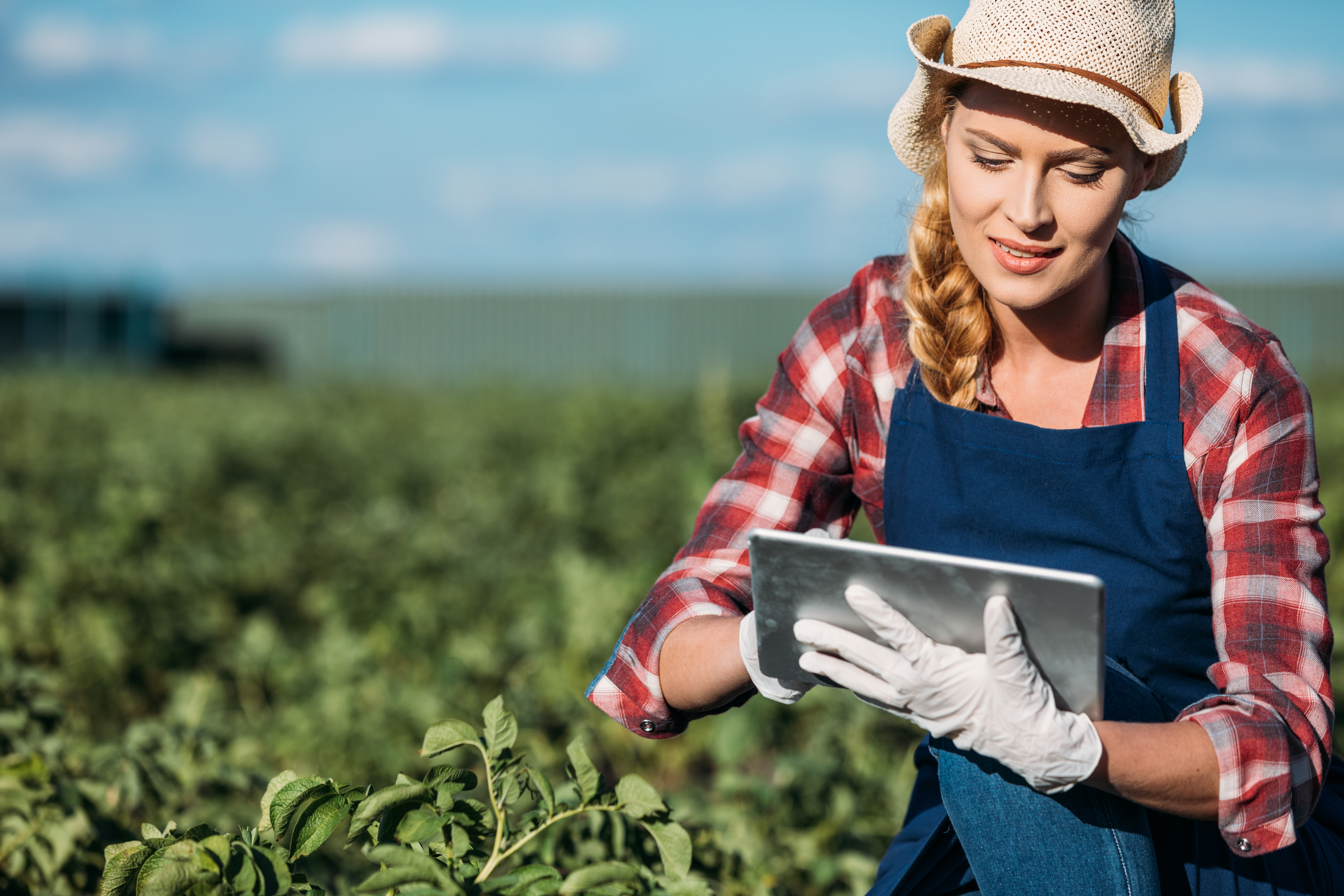 women in field with tablet